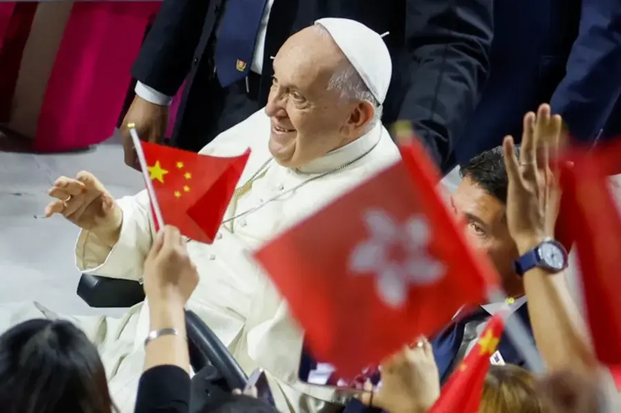 People wave Chinese and Hong Kong flags, as Pope Francis arrives to attend the Holy Mass in Ulaanbaatar, in Mongolia in September [Carlos Garcia Rawlins/Reuters]