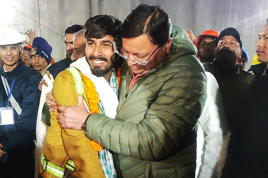 Chief minister of Uttarakhand Pushkar Singh Dhami (R) embracing a contruction worker following his rescue from inside the under construction Silkyara tunnel in India's Uttarakhand state on November 28, 2023. © Department of Information and Public Relation (DIPR) Uttarakhand / AFP