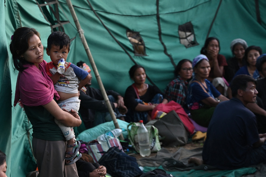 People wait at a temporary shelter in a military camp, after being evacuated by the Indian army, as they flee ethnic violence that has hit the northeastern Indian state of Manipur on May 7, 2023. © Arun SANKAR / AFP