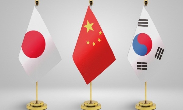 The trilateral summit measures South Korea's diplomatic shift.