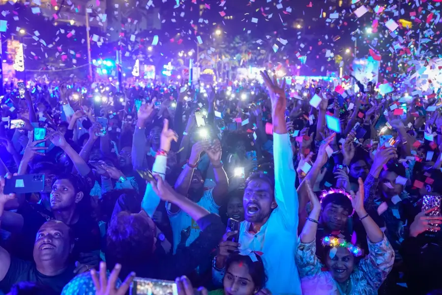 People celebrate New Year at a promenade in the Indian city of Mumbai [Rafiq Maqbool/AP Photo]