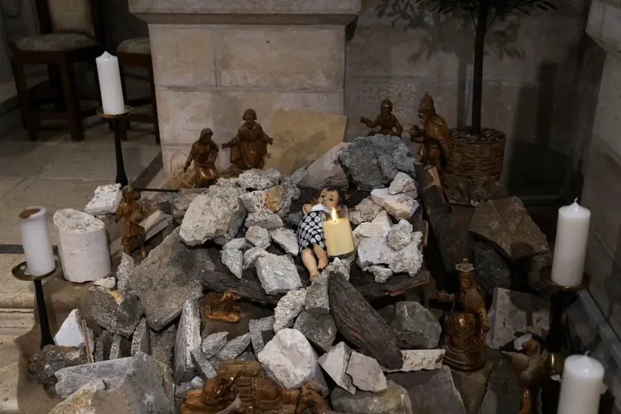An installation of a scene of the Nativity of Christ with a figure symbolising baby Jesus lying amid the rubble, in reference to Gaza, inside an Evangelical Lutheran Church in the West Bank town of Bethlehem, on December 12. Christmas celebrations in Bethlehem were put on hold due to the continuing Israel-Gaza war. [Mahmoud Illean/AP Photo]