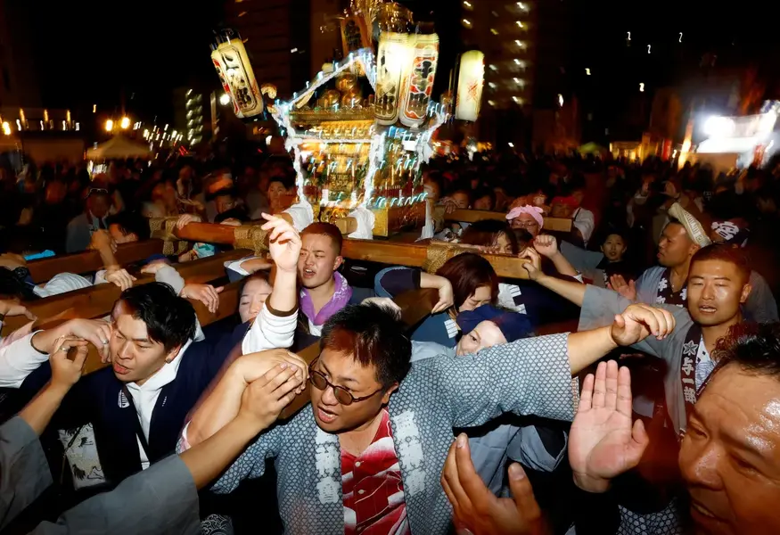 People carry an illuminated 'mikoshi' or portable shrine during a countdown event to celebrate the New Year in Yokosuka, Japan, south of Tokyo [Kim Kyung-Hoon/Reuters]