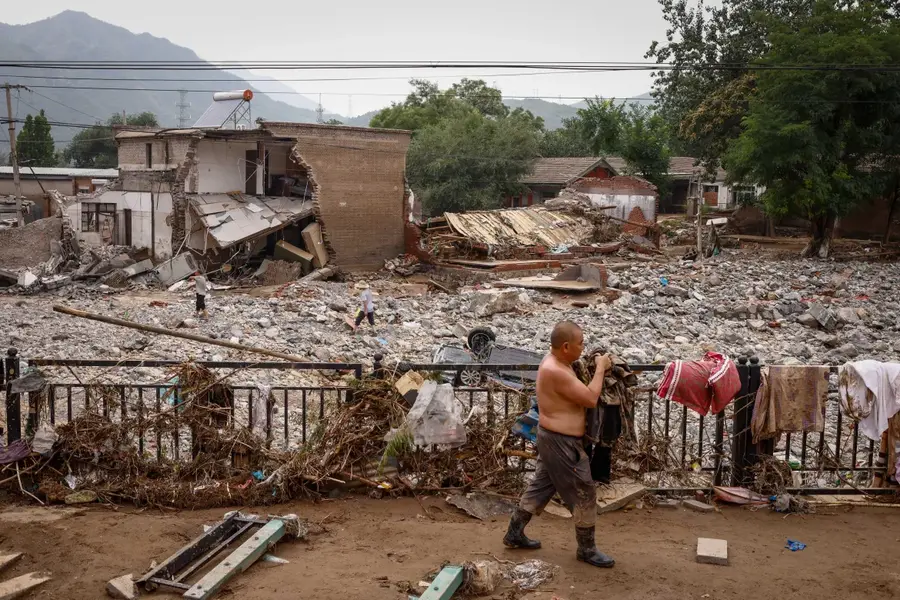 A man recovers belongings from his house following floods in the mountains of Mentougou district, west of Beijing, China, on August 4, 2023. Beijing recorded its heaviest rainfall in 140 years as Typhoon Doksuri caused the evacuation of thousands and 21 deaths. [Mark R. Cristino/EPA-EFE]