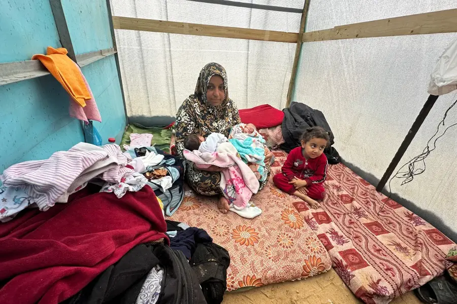 The grandmother of Salma and Alma al-Jadba, twin Palestinian baby girls who were born during the war, holds them in a tent where they shelter with their displaced family who fled their house due to Israeli attacks, in Rafah in the southern Gaza Strip December 17, 2023. [Fadi Shana/Reuters]